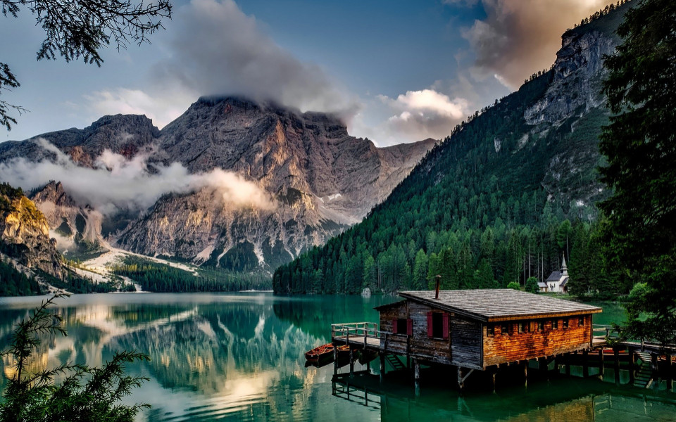 Holzh&uuml;tte auf einem See mit Berglandschaft