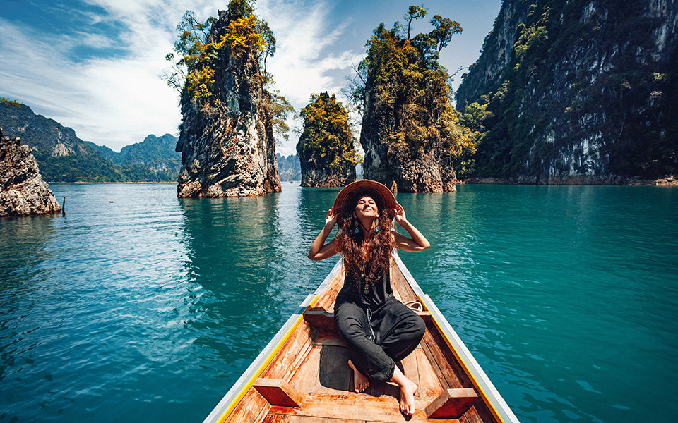 Fr&uuml;hbucher Rabatte: Frau mit Hut auf einem Boot in Thailand